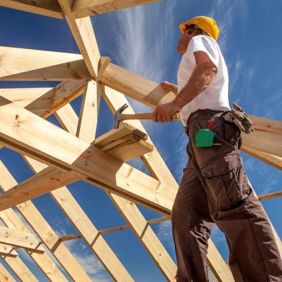 worker roofer builder working on roof structure on construction site
